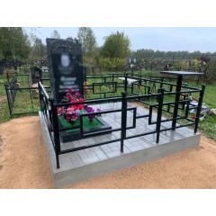 Строгий мемориальный комплекс из черного гранита с резным крестом и геометричной оградой