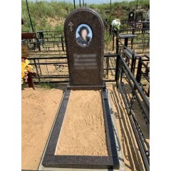 Вертикальный памятник из коричневого гранита с арочным завершением и открытым цветником